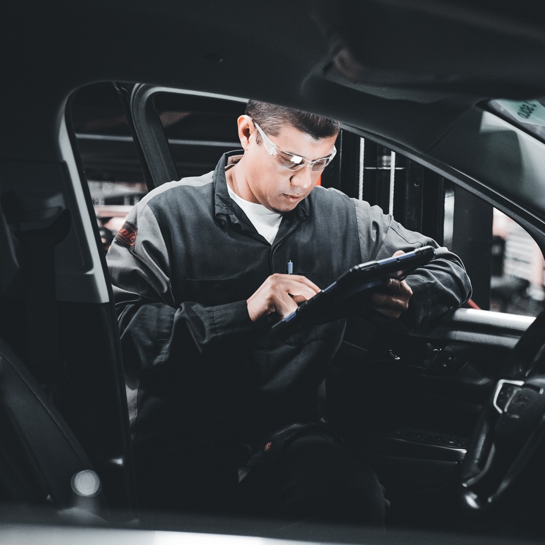 Illustrative photograph of a technician recording inspection information inside a vehicle