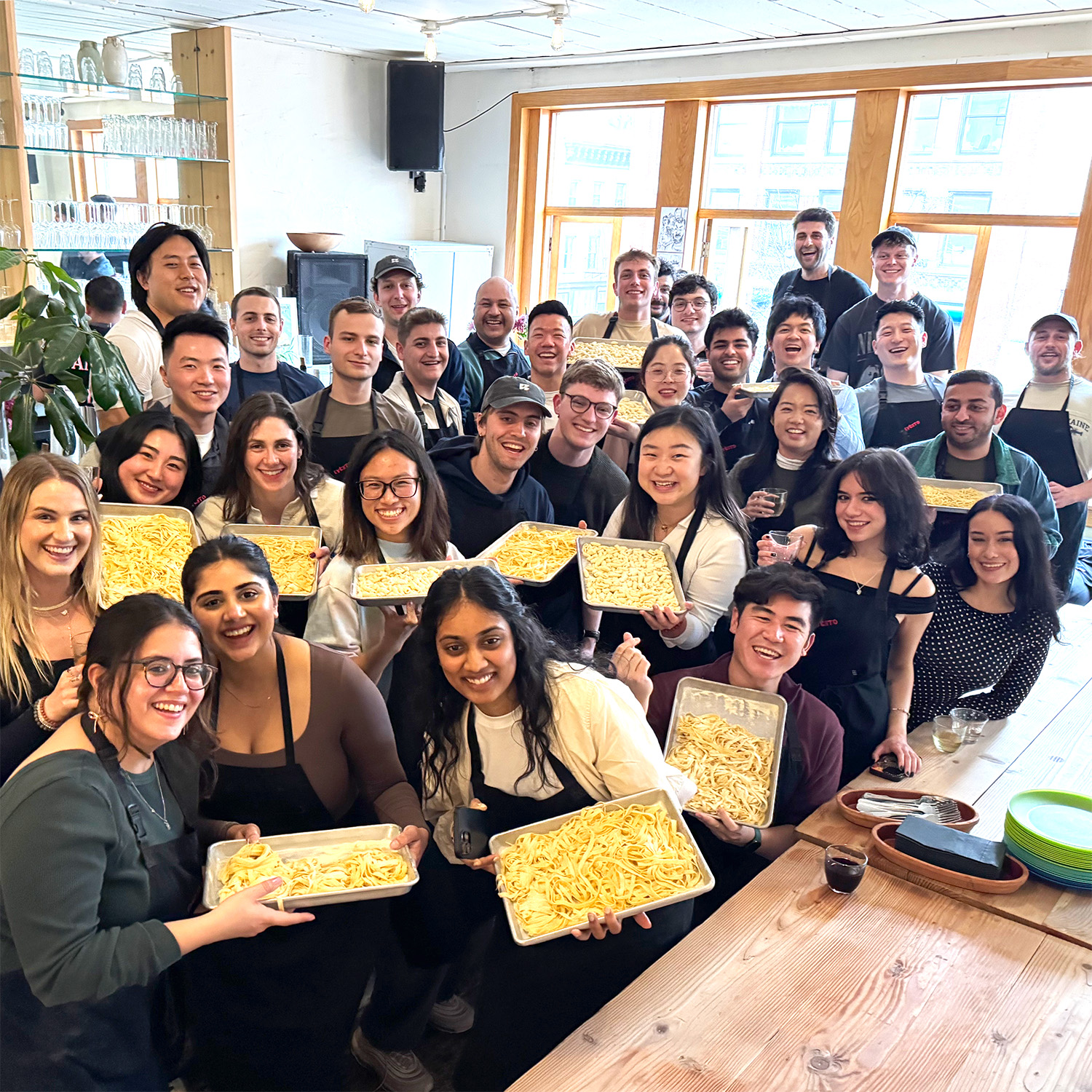 RepRally team smiling and holding trays of freshly made pasta