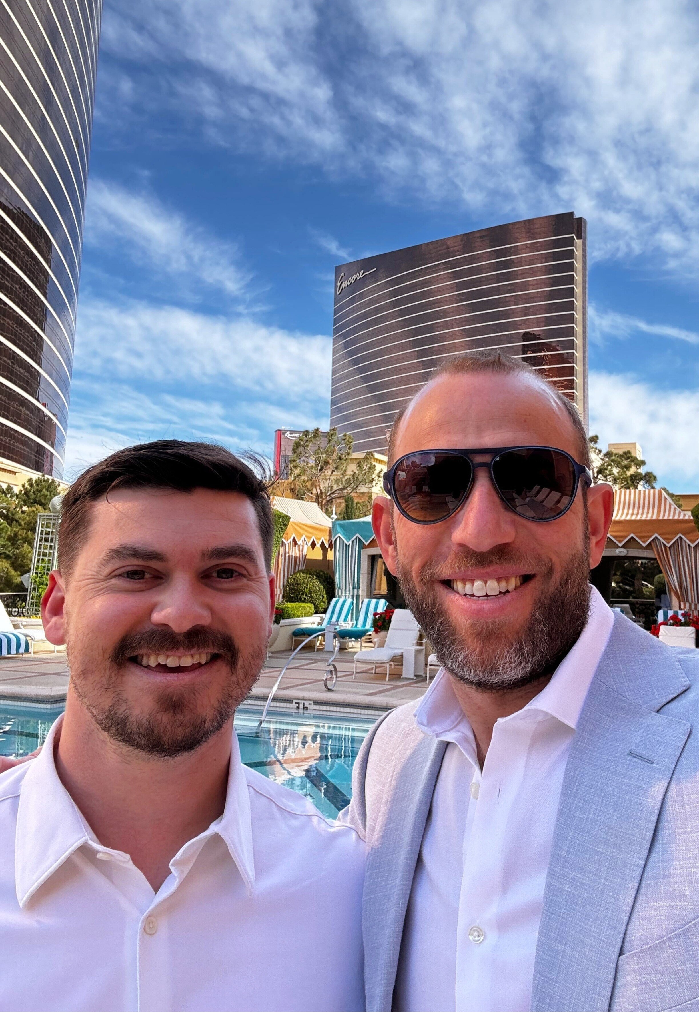 Two people in a company-published photograph beside a hotel pool at Encore