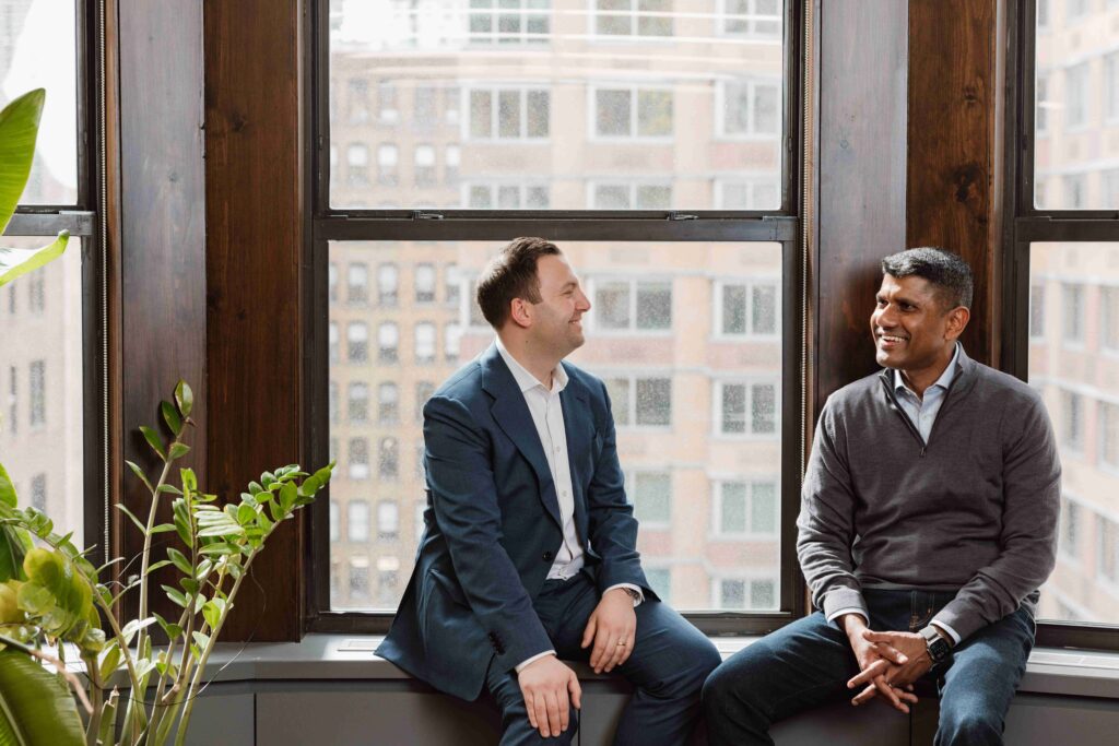 Chief People Officer Mike Lamm, left, talking with CEO Dinesh Senanayake beside office windows