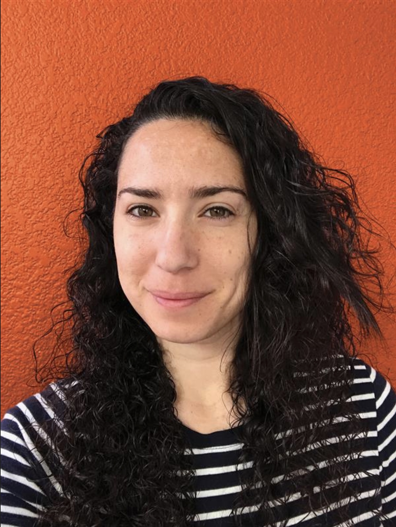 Rev One founder Natasha Lahlouh, pictured against an orange wall