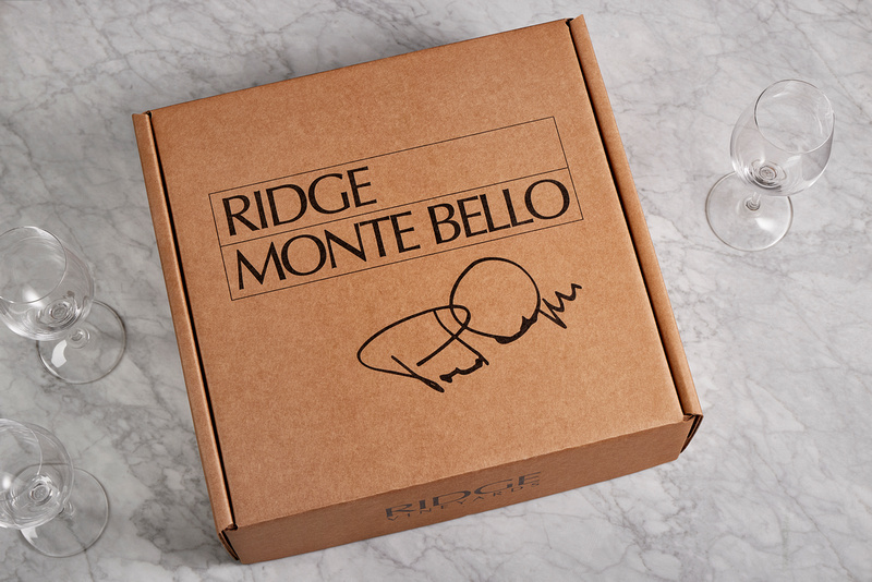Ridge Monte Bello paper wine box with black lettering and Paul Draper’s signature, beside wine glasses