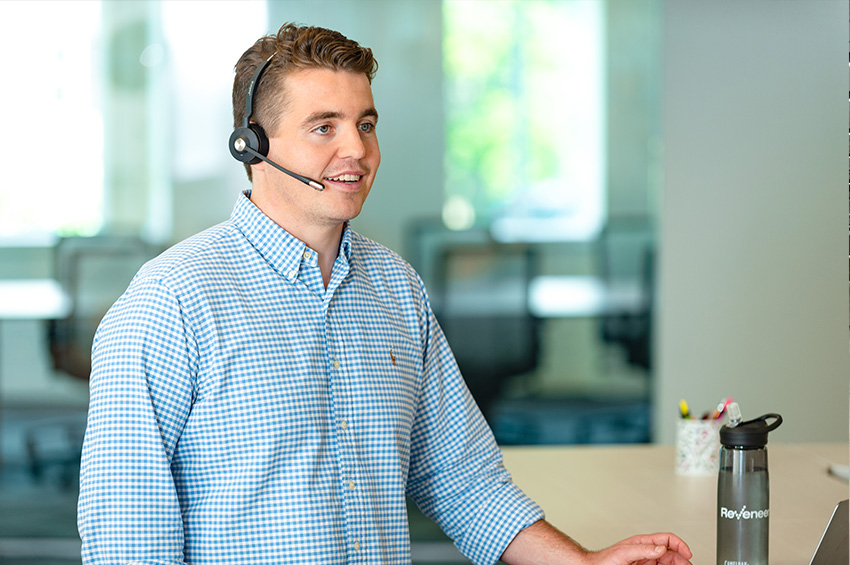 A Reveneer employee wearing a headset at work