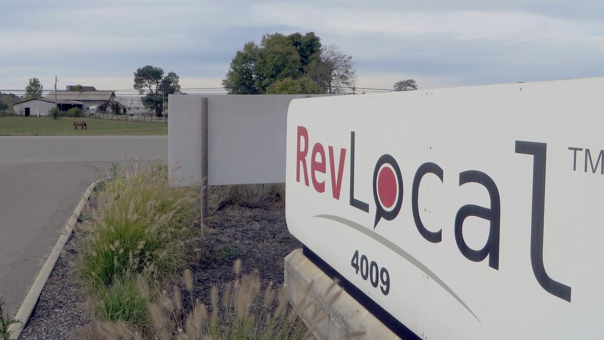 RevLocal sign at its former Granville headquarters, with a horse grazing across the road