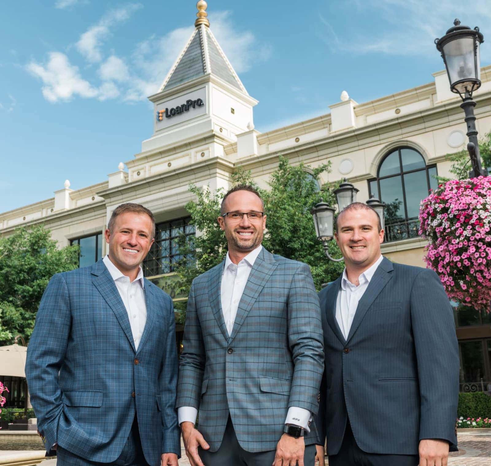 LoanPro co-founders Ben, Lloyd, and Rhett Roberts standing together outside the company office