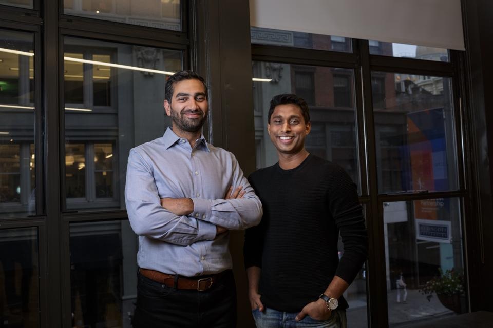 Rhino co-founders Ankur Jain, left, and Paraag Sarva, right, standing by office windows