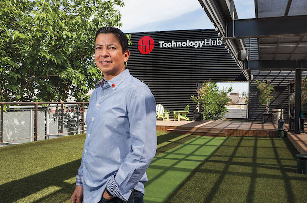 Ricardo Mora standing outside Technology HUB beside its lawn and office buildings