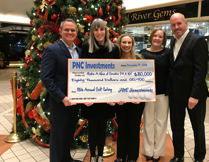 PNC Investments representatives gathered around an $80,000 donation check at a Make-A-Wish presentation