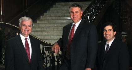 HUB executives John Curran, Richard Gulliver and Bruce Guthart standing beside a staircase