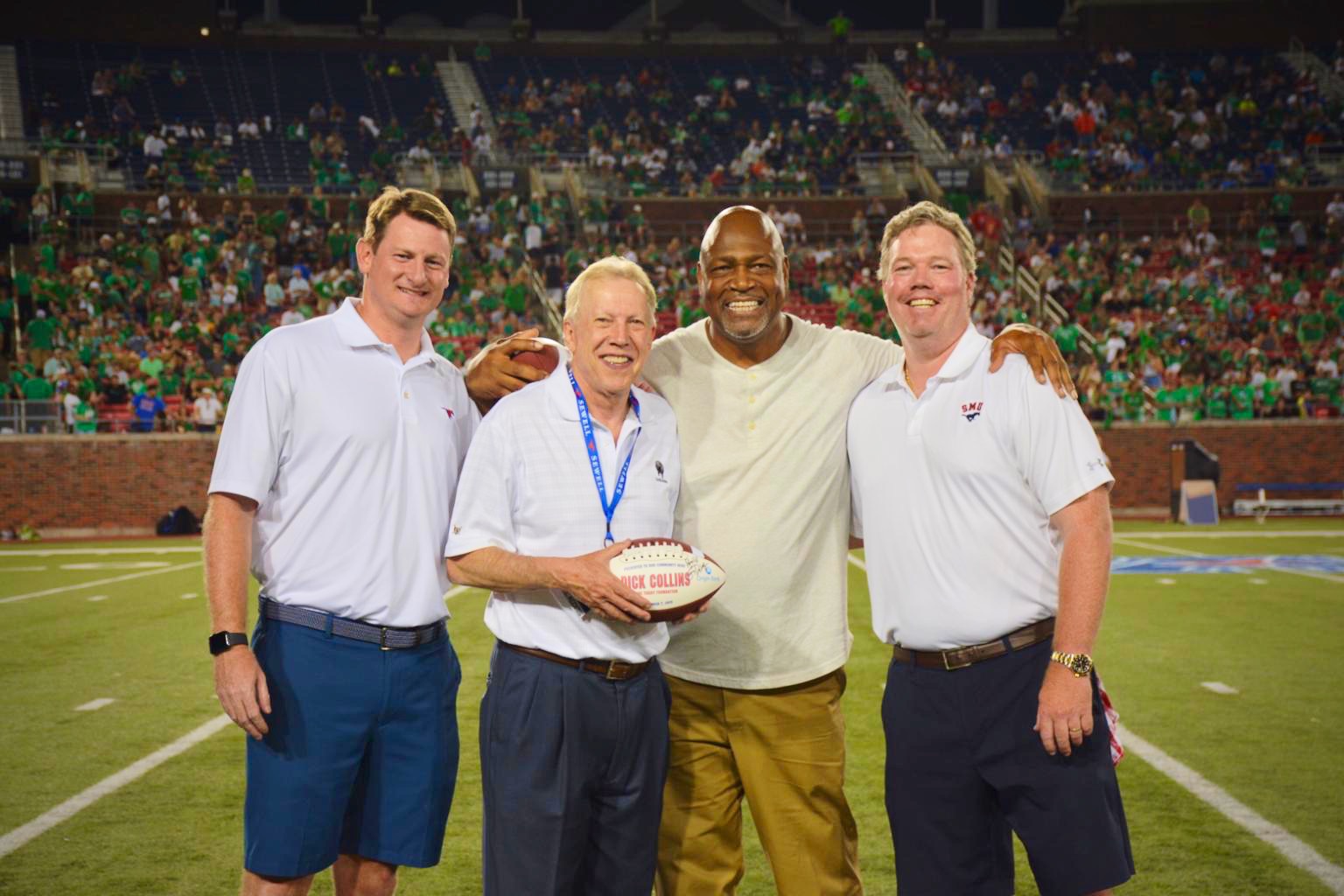 Richard Collins, second from left, and Charles Haley receiving community recognition on the field at an SMU football game.