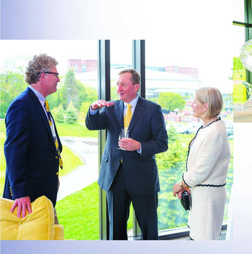 Architect Mike DeVries, left, speaks with Rich Postma, center, and Ruth Postma at the Michigan clubhouse dedication