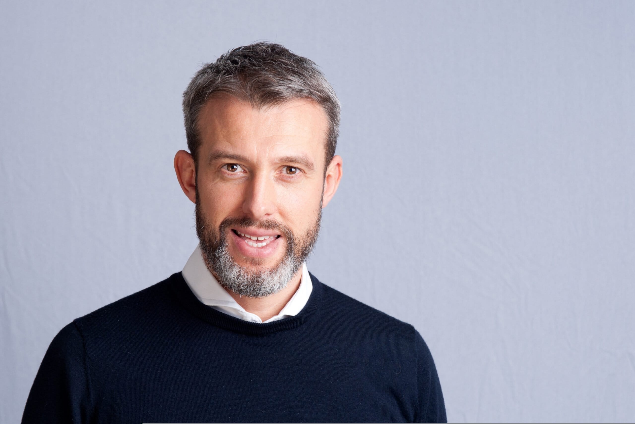 Richard Prime in a navy jumper and white shirt in a press portrait