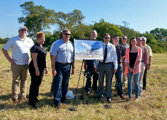 A group pictured beside an architectural rendering in Gemini Investments’ company profile