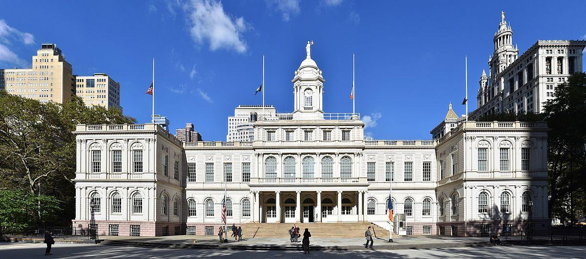 The symmetrical stone facade and clock tower of New York City Hall