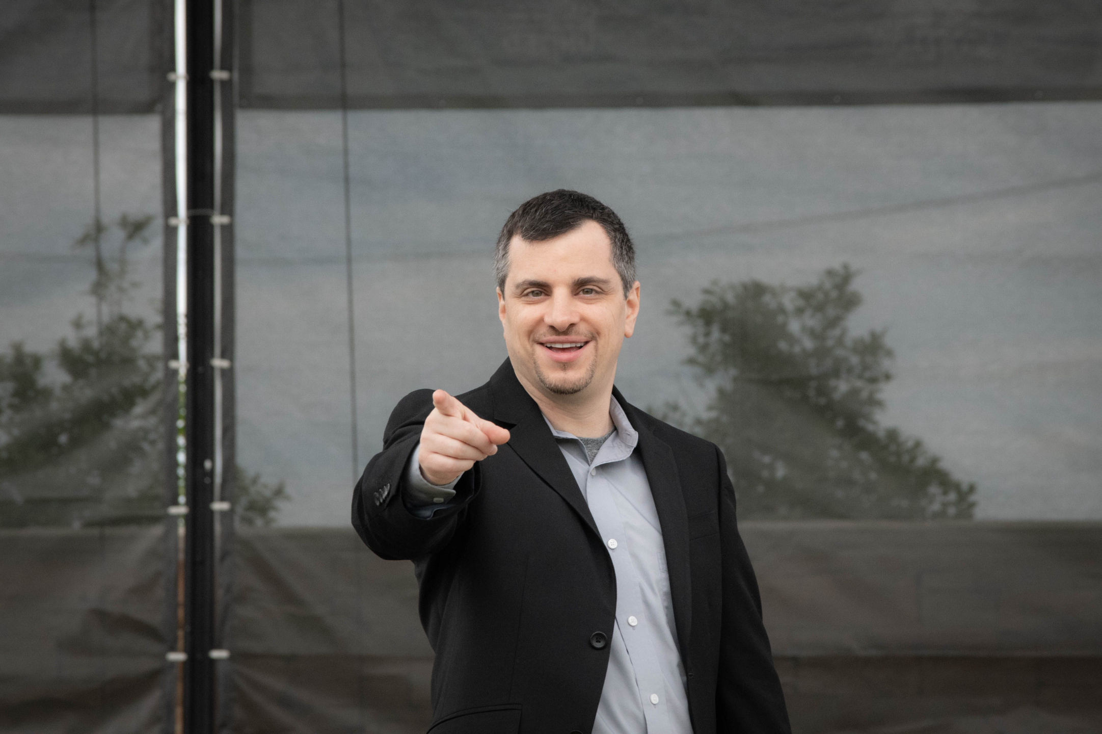 Richard Shuster speaking on an outdoor stage