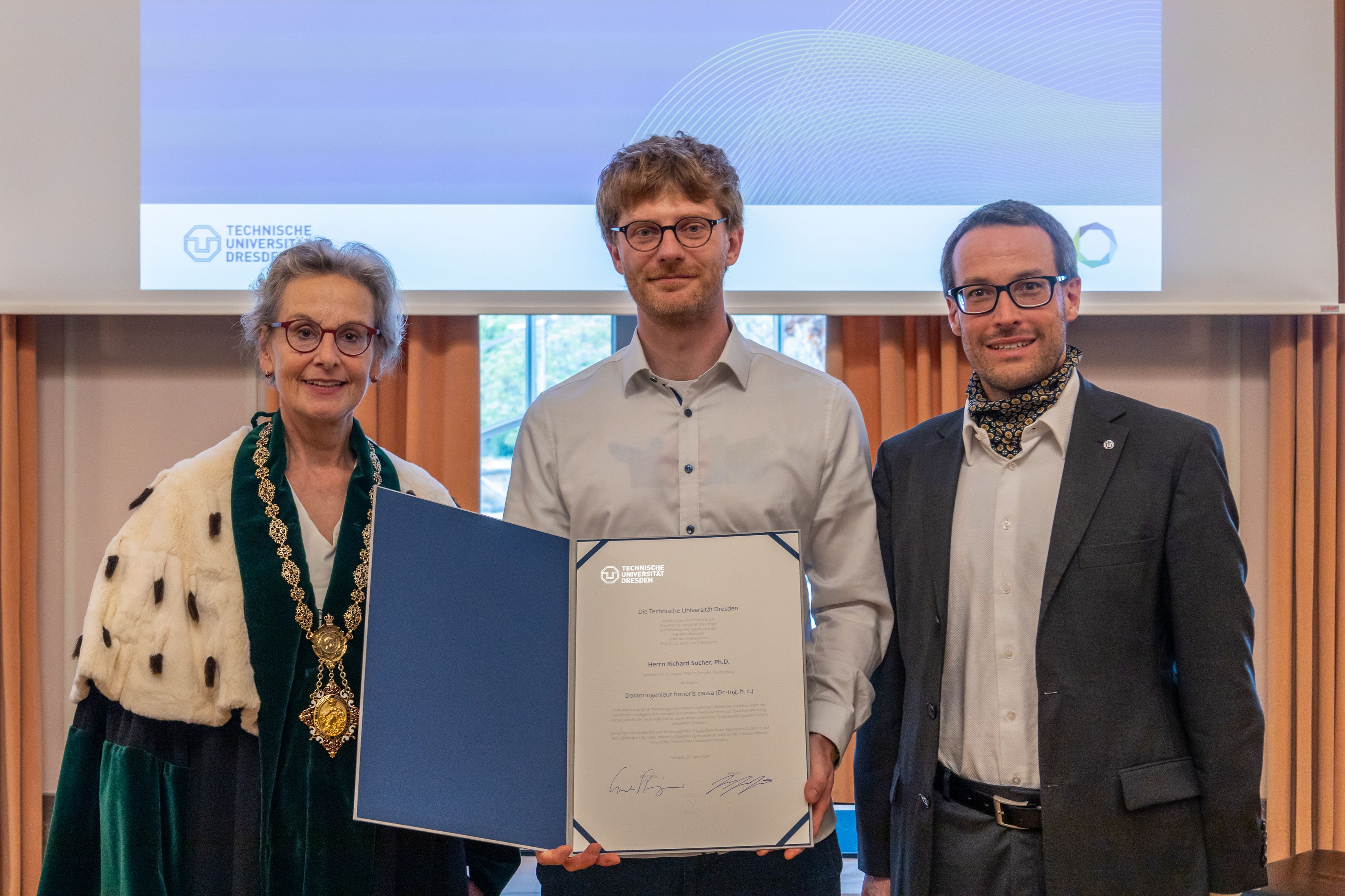 Richard Socher holds his honorary doctorate between Ursula Staudinger and Ivo Sbalzarini at TU Dresden