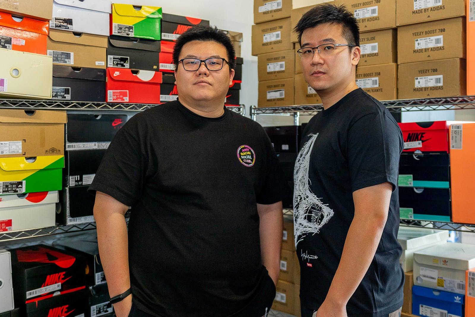 Richard Xia, left, and co-founder Chris Xue standing among shelves of sneaker boxes
