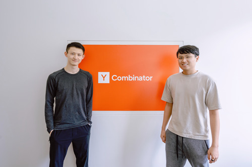 Richard Zhang and Alan Lu standing beside a Y Combinator display