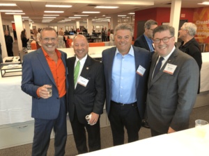 Rick Chiorando, at left in an orange shirt, with three clients at the Austin Williams office-warming party