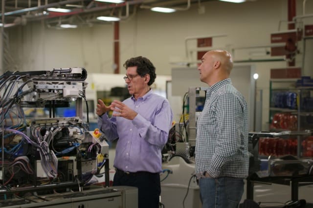 Rick Cohen, left, discussing industrial machinery with a colleague at Symbotic