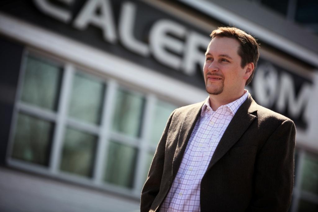 Rick Gibbs standing outside the Dealer.com building in a historical company photograph
