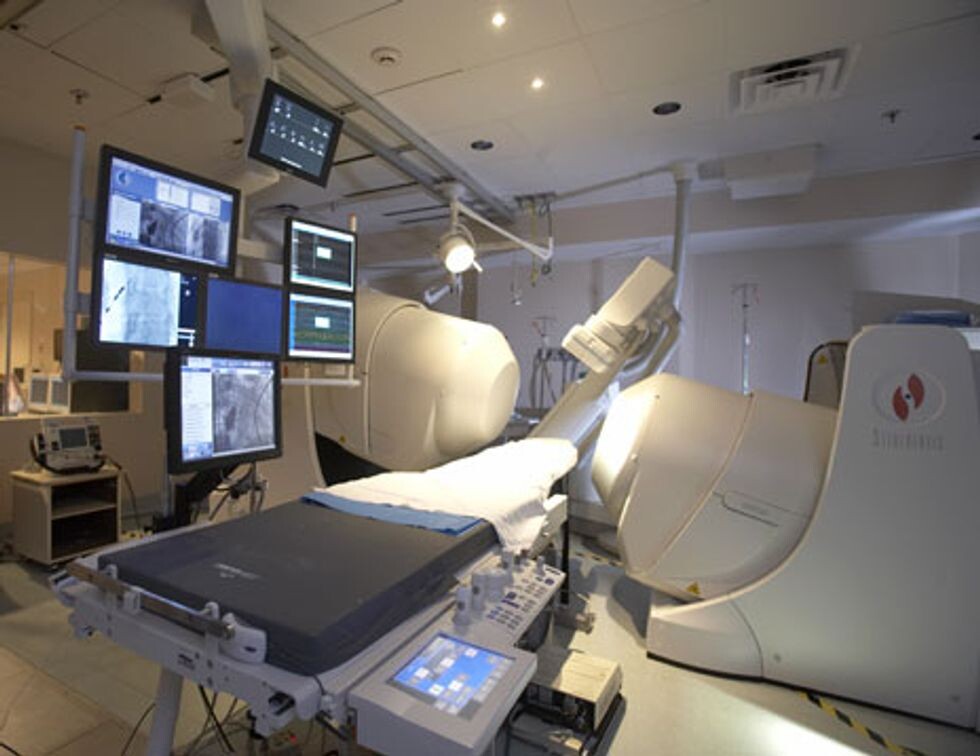 A Stereotaxis magnetic navigation laboratory with procedure table, imaging equipment and multiple monitors