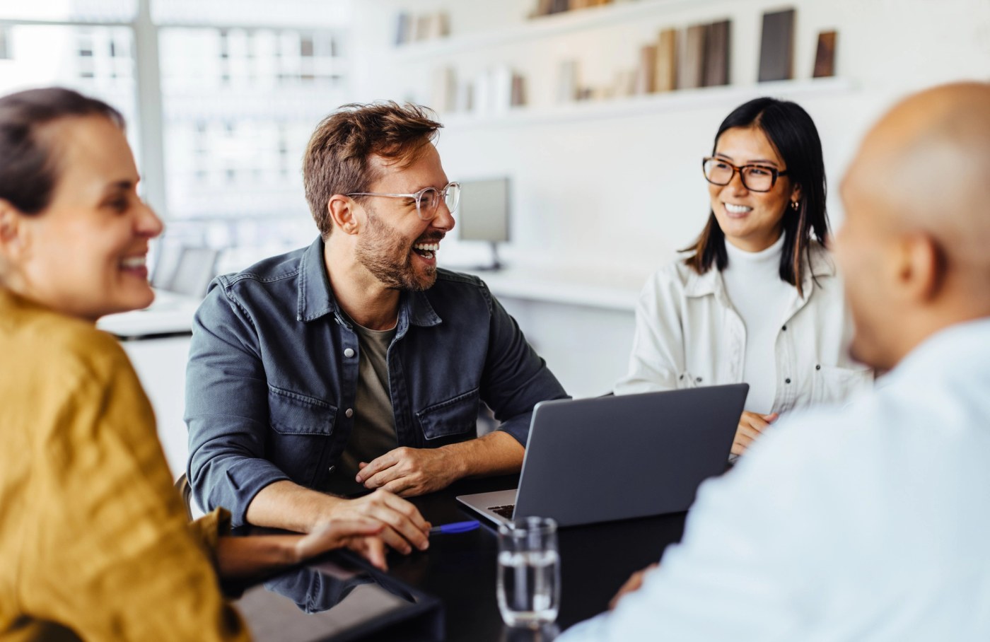 People collaborating around a laptop in a photograph from Rightway’s careers page