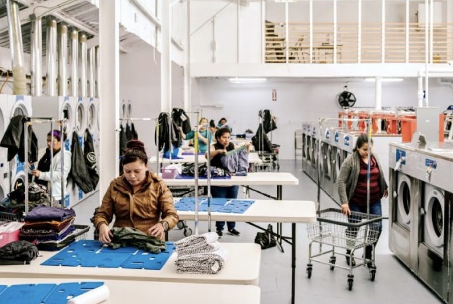 Employees at a Rinse cleaning partner folding laundry