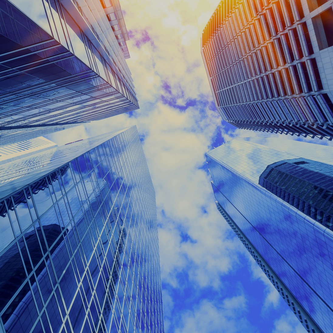 Office towers viewed upward around a patch of sky