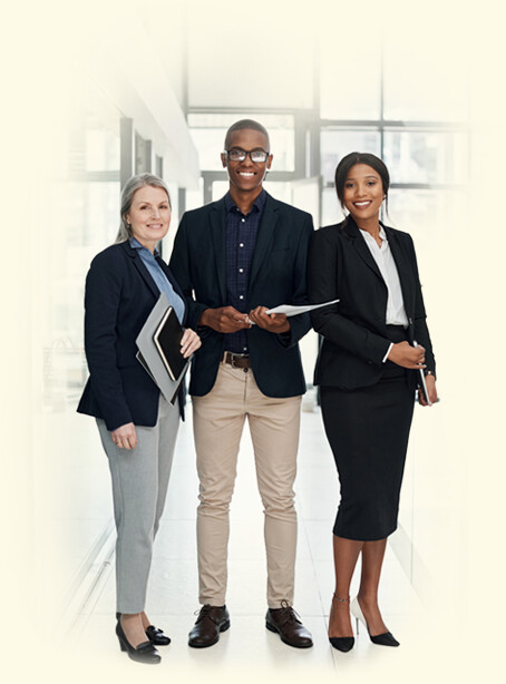 Three business professionals standing together in a bright office corridor
