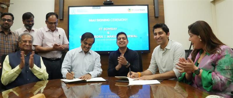 Ritesh Arora, seated second from right, signs documents at the IIT Bombay pledge ceremony alongside institute representatives and Nakul Aggarwal.