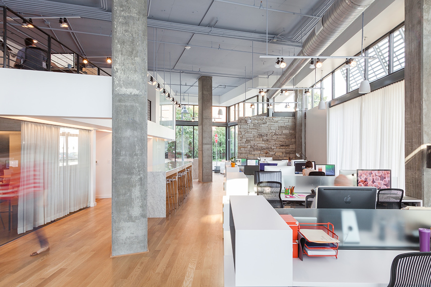 Rivers Agency's open-plan Chapel Hill studio with workstations, concrete columns and a mezzanine
