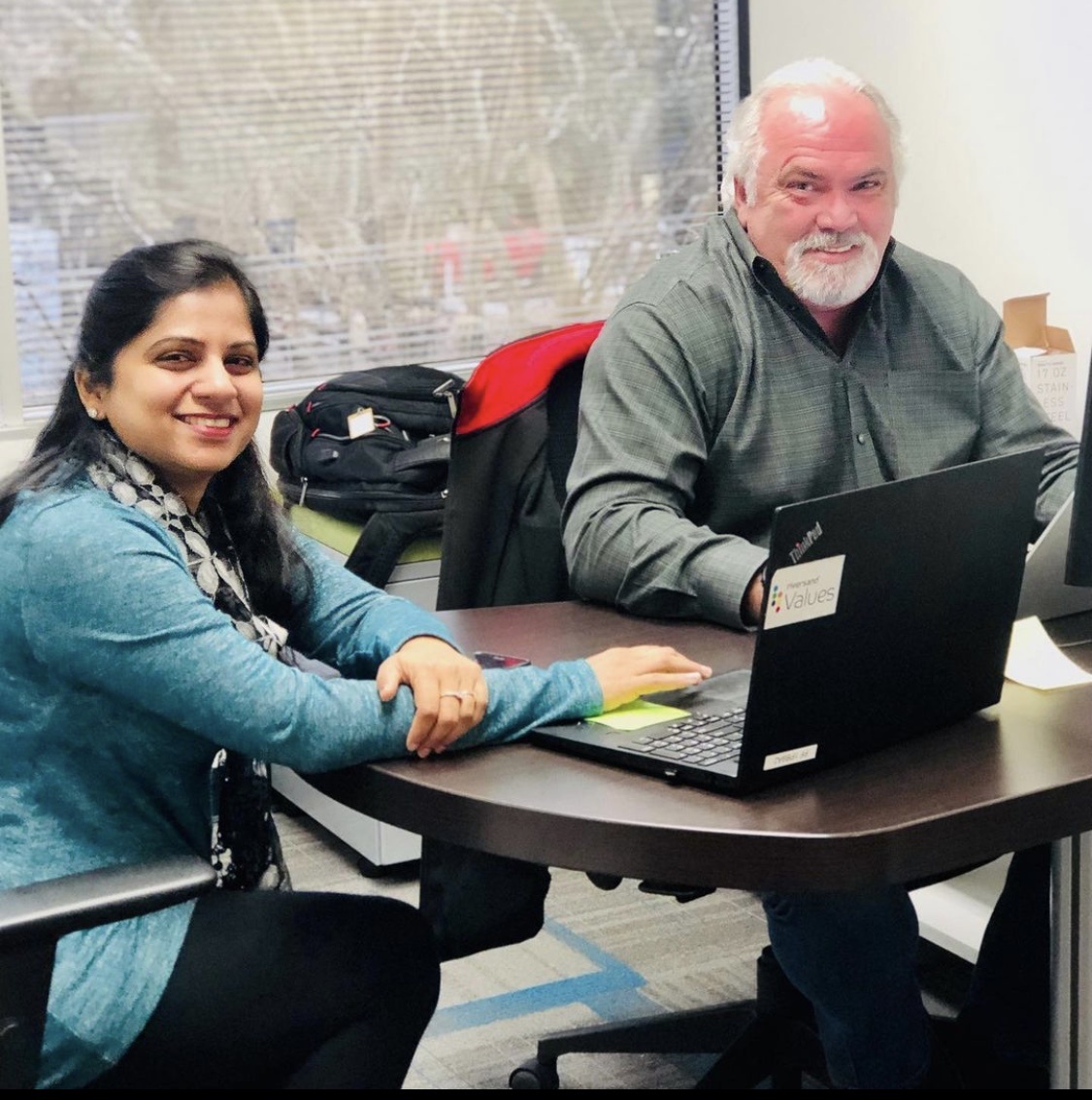 Two Riversand colleagues working together at a table with laptops