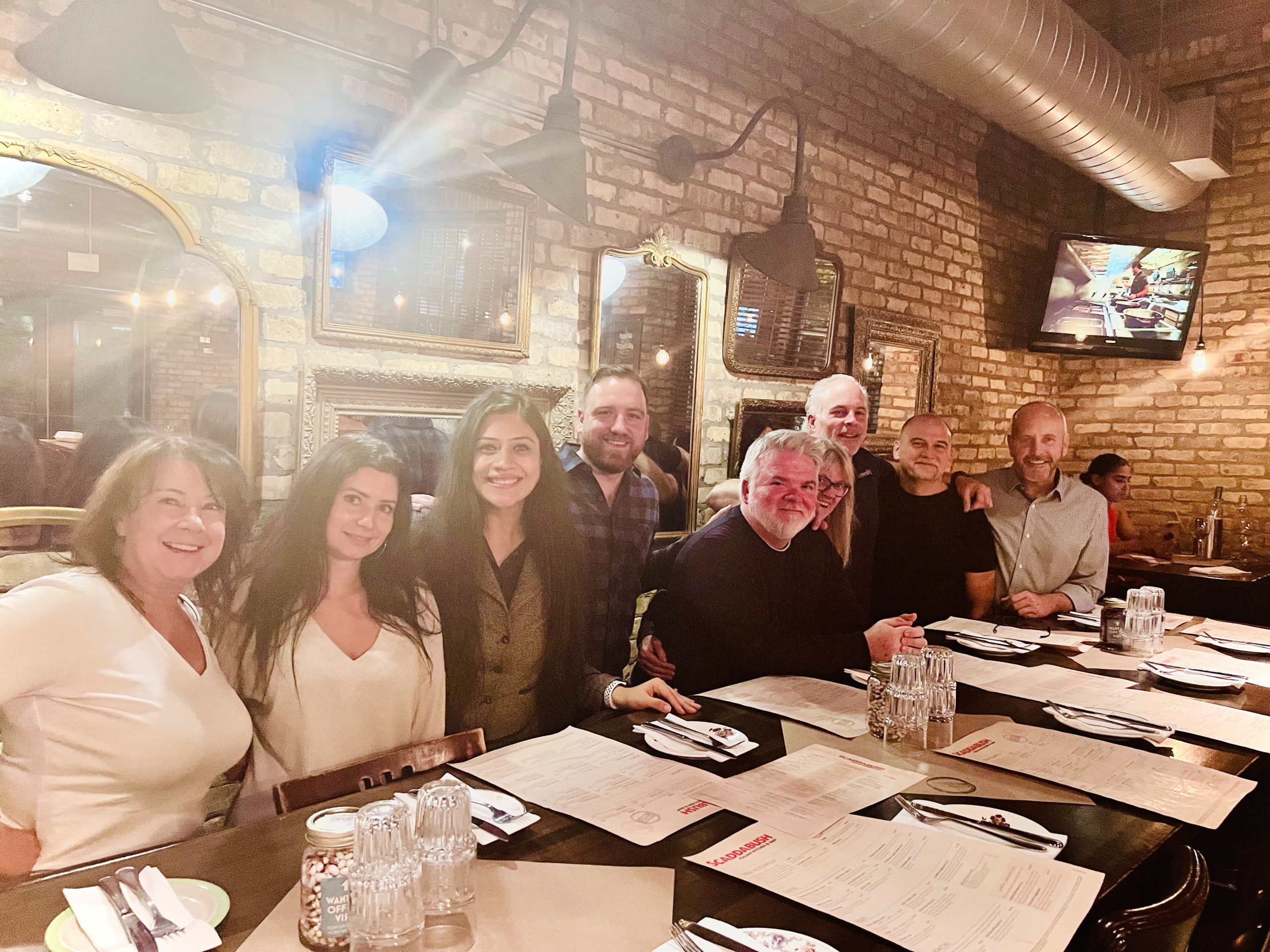 A group of company colleagues gathered around a restaurant table