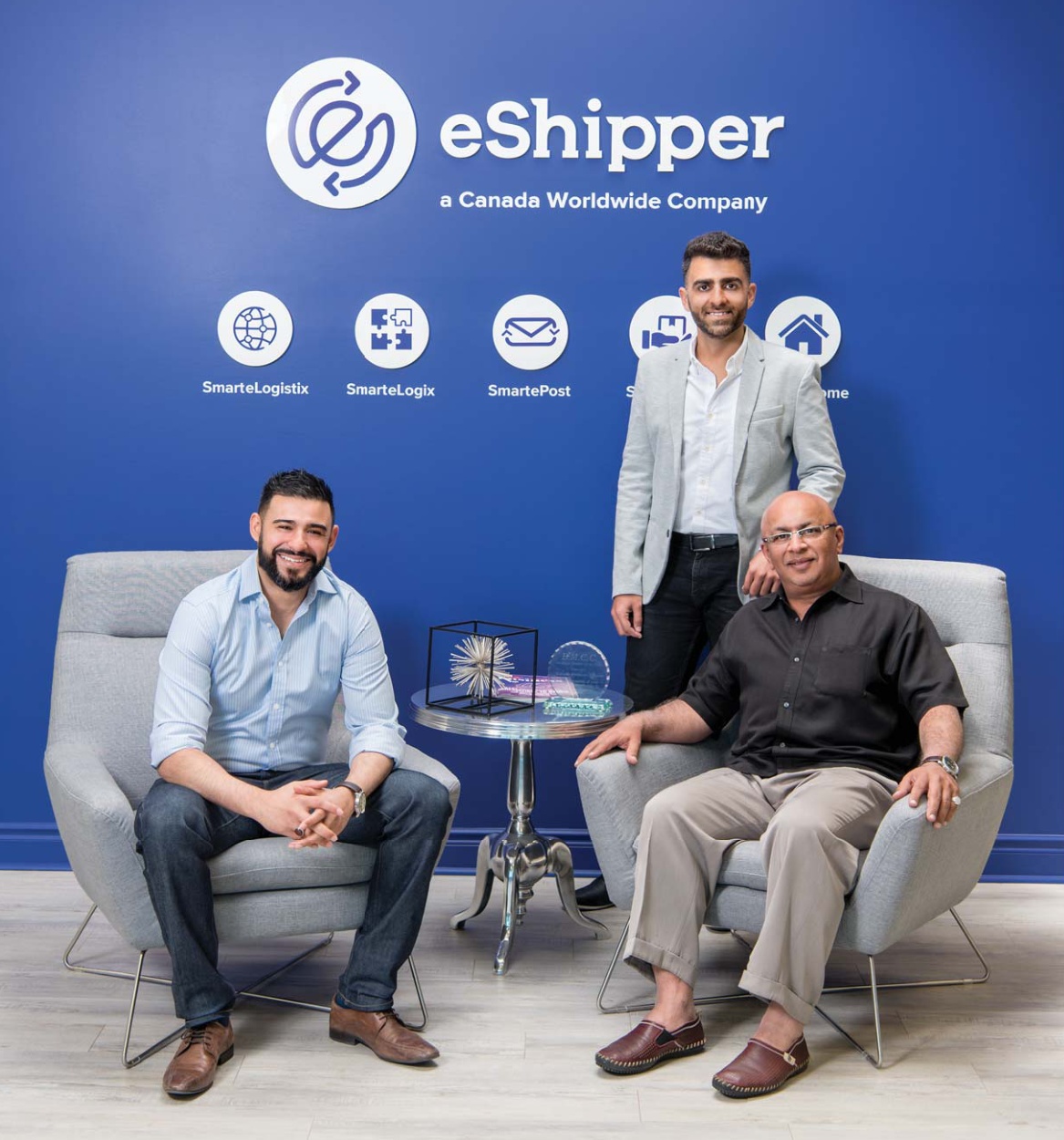 Rizwan Kermalli seated at right, Imtiaz Kermali seated at left and Mo Datoo standing in eShipper’s office