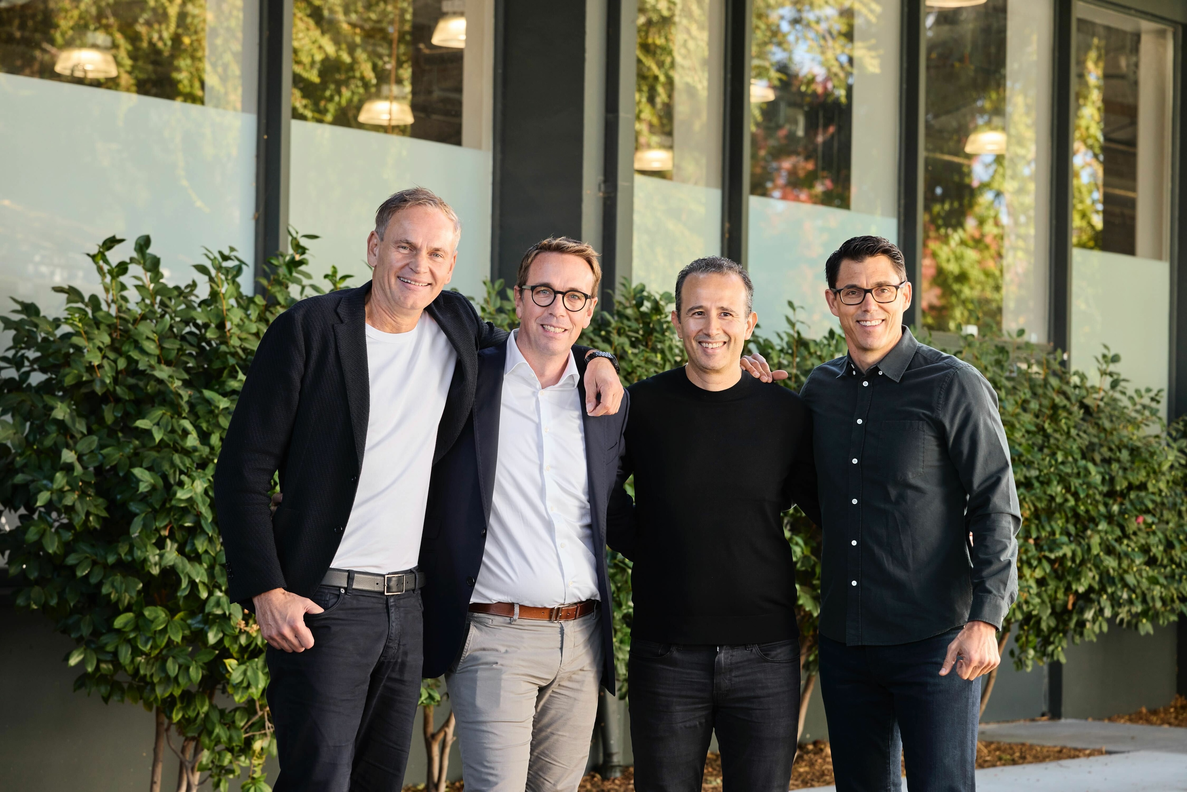Oliver Blume, Carsten Helbing, Wassym Bensaid and RJ Scaringe standing together at the Rivian and Volkswagen joint-venture announcement.