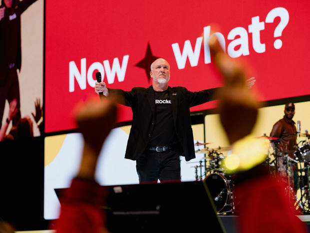 Rocket all-company meeting, with a presenter onstage and audience members raising their hands