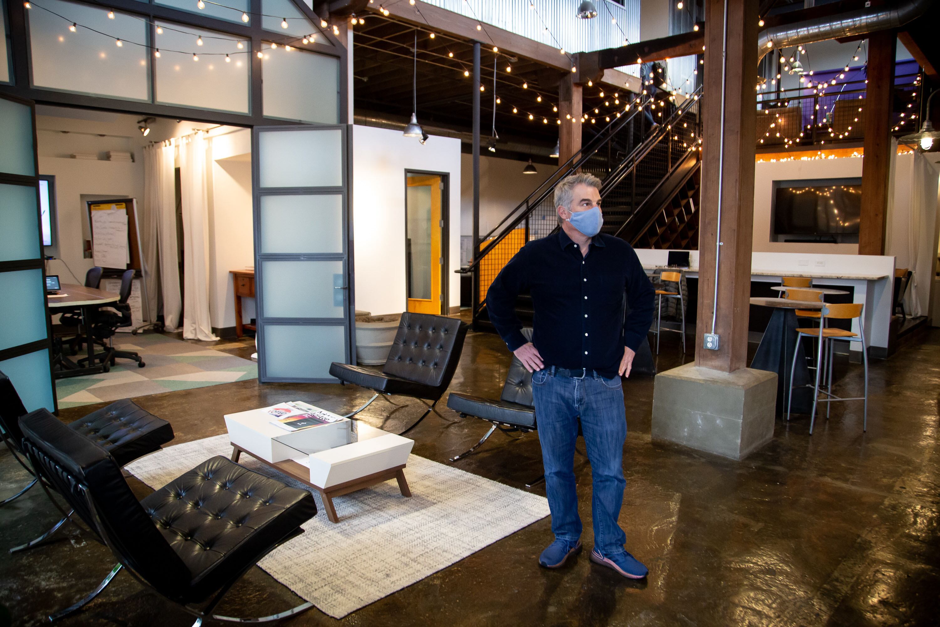 Rob Farinella standing among the seating, timber columns and staircase at Blue Sky Agency’s Atlanta office.