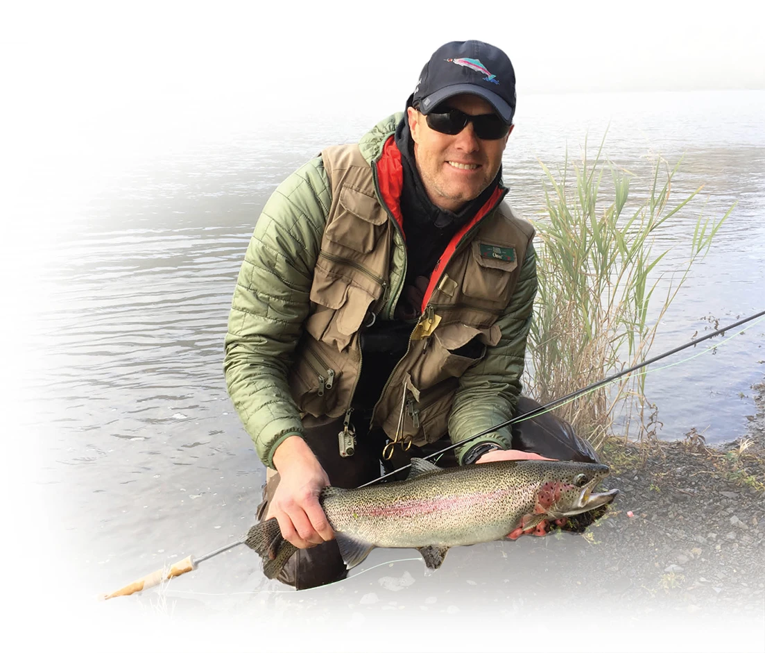 Rob Gillam holding a fish outdoors in Alaska