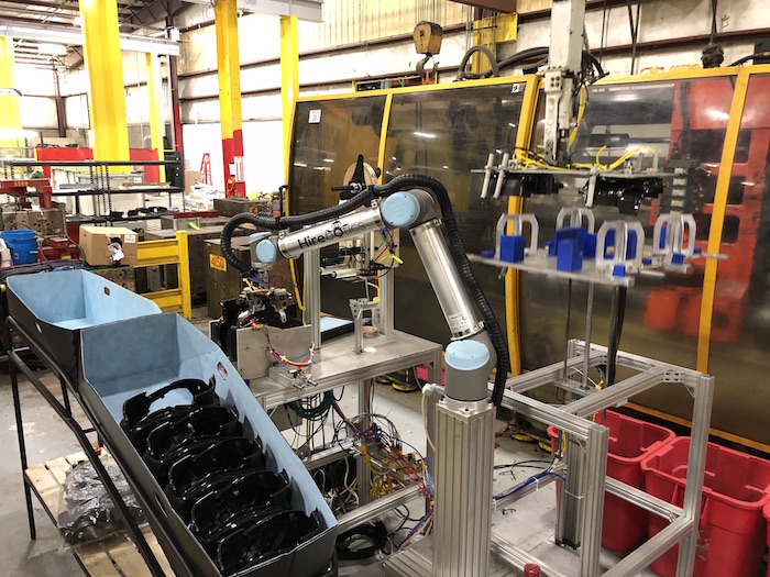 An early Hirebotics collaborative robot working beside production machinery on a factory floor