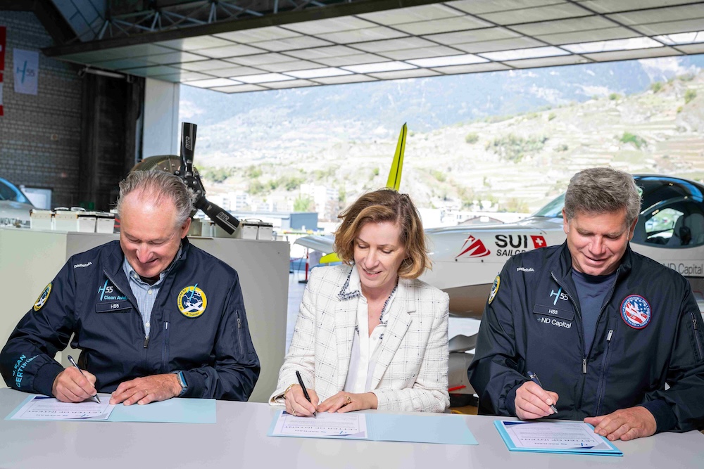 André Borschberg, Agnès Pronost Gilles and Rob Solomon sign the H55 and Safran agreement in an aircraft hangar.