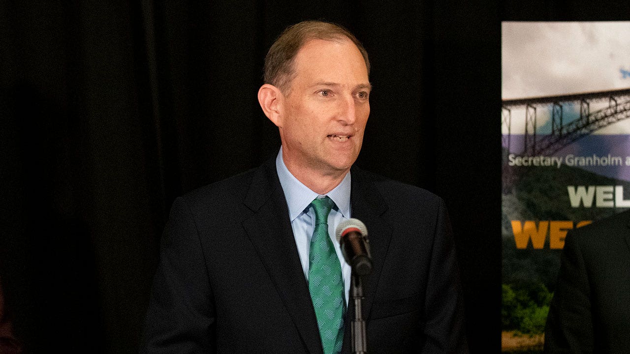 Robert Blue speaking into a microphone at a news conference