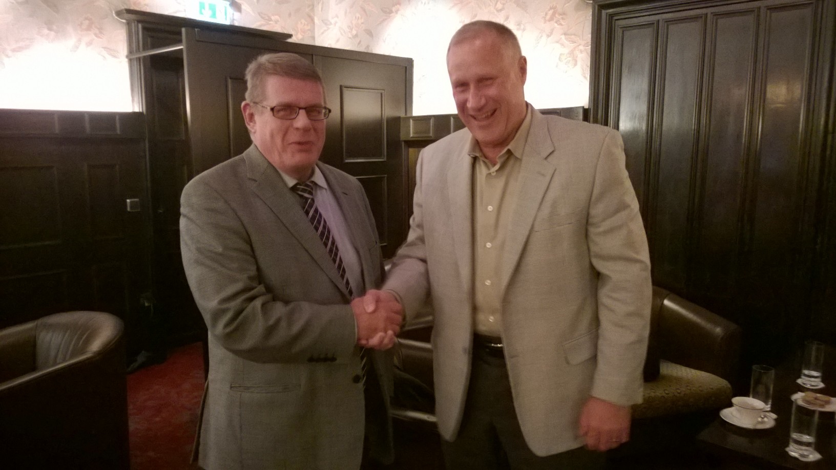Risto Finne and Robert DeJean shake hands at the Systech and Servicepoint partnership signing