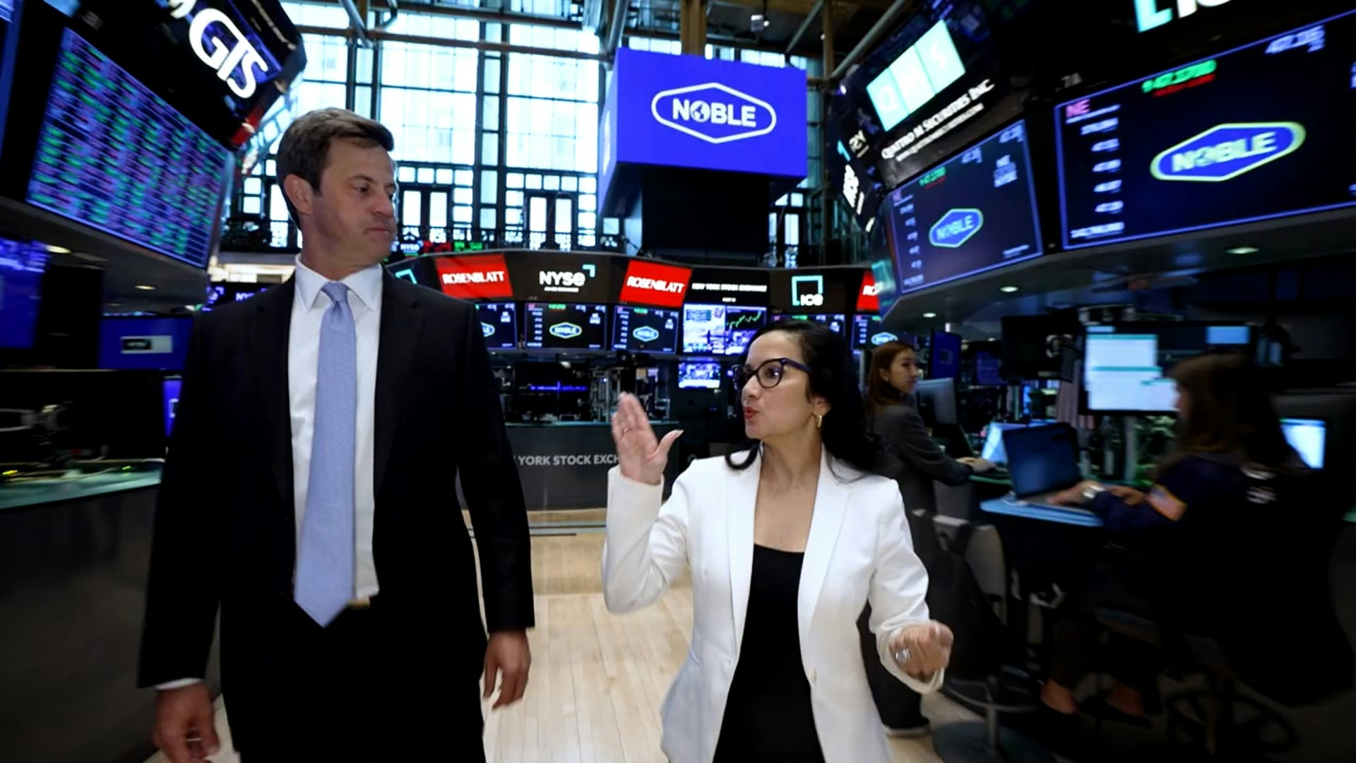 Robert Eifler standing with an interviewer on the New York Stock Exchange trading floor