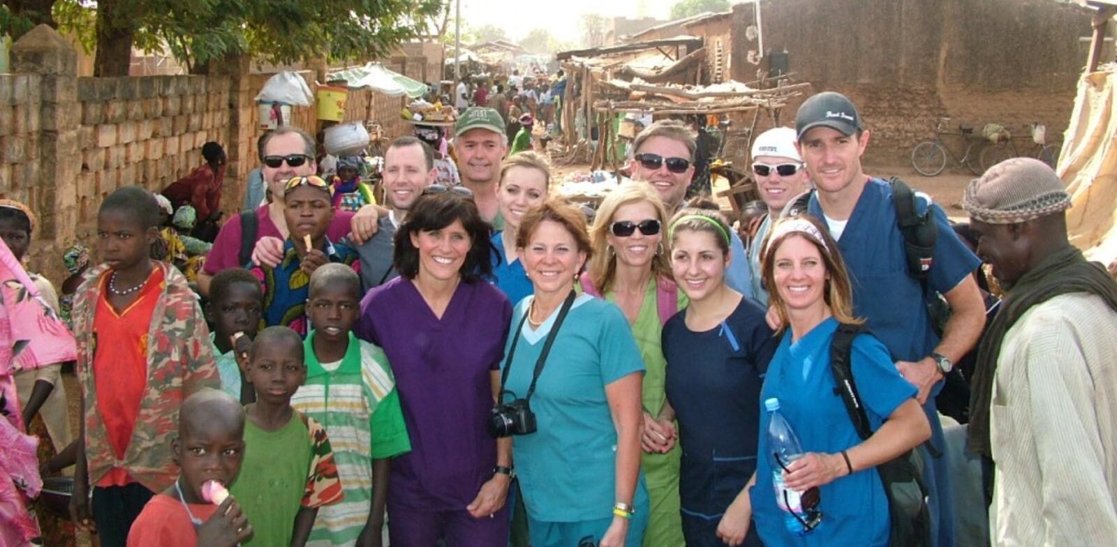 Robert Ferrell and a dental service team smiling together during humanitarian work in Africa