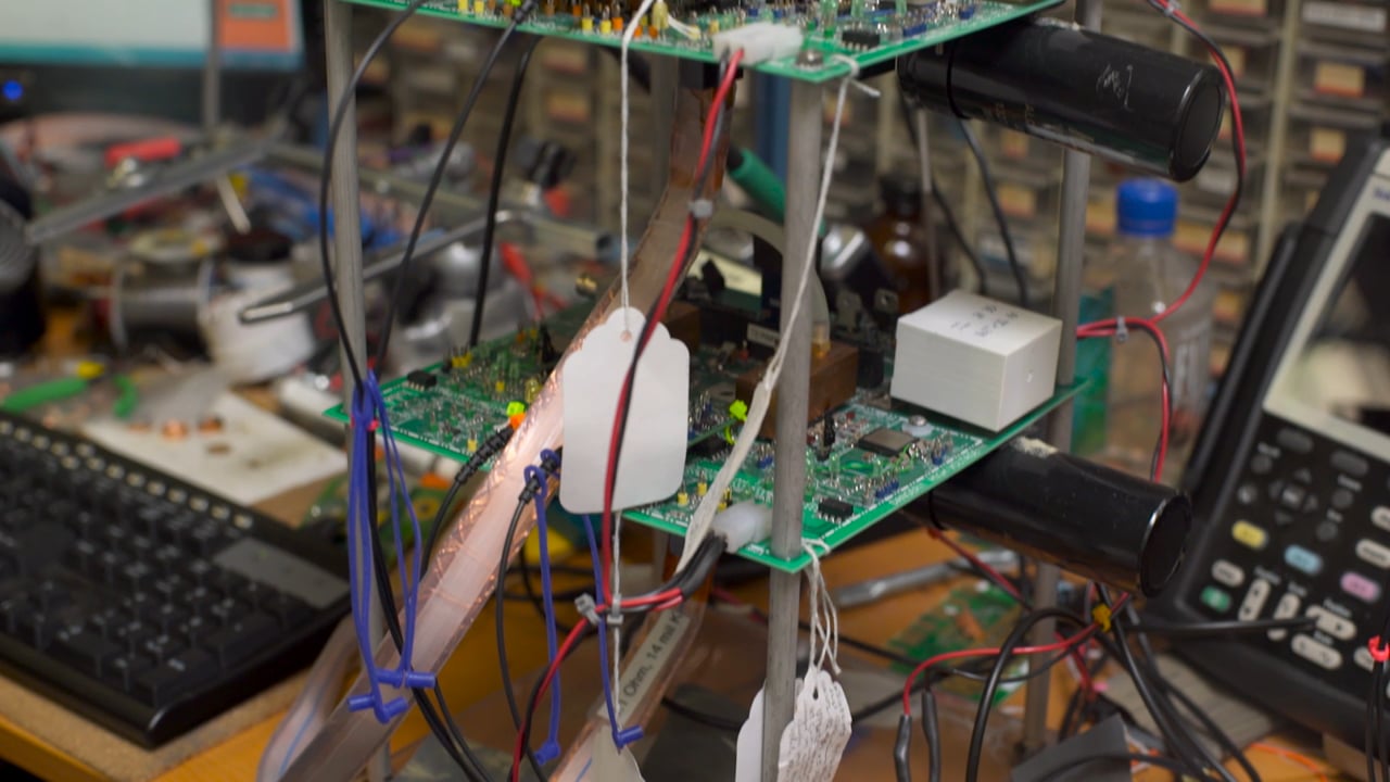 Circuit boards, test equipment, cables, and sensors on a Brillouin Energy laboratory bench