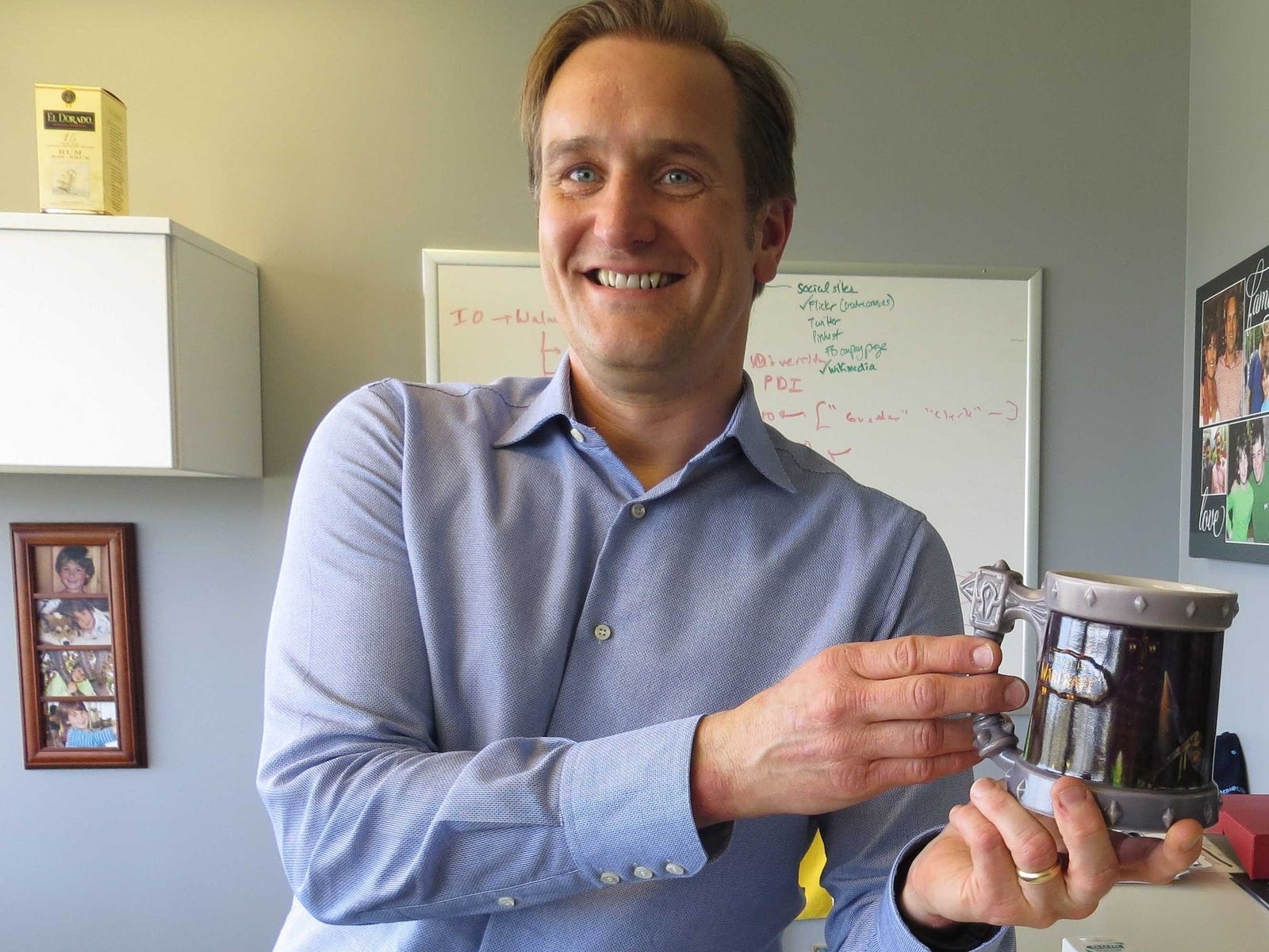 Robert Hohman in his office holding a World of Warcraft mug