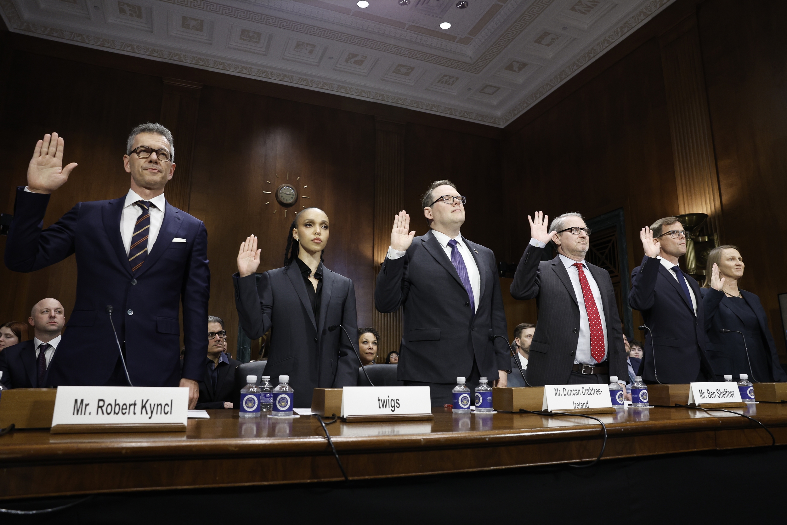 Robert Kyncl, at left, raises his hand alongside FKA twigs and other witnesses at the April 2024 Senate hearing.