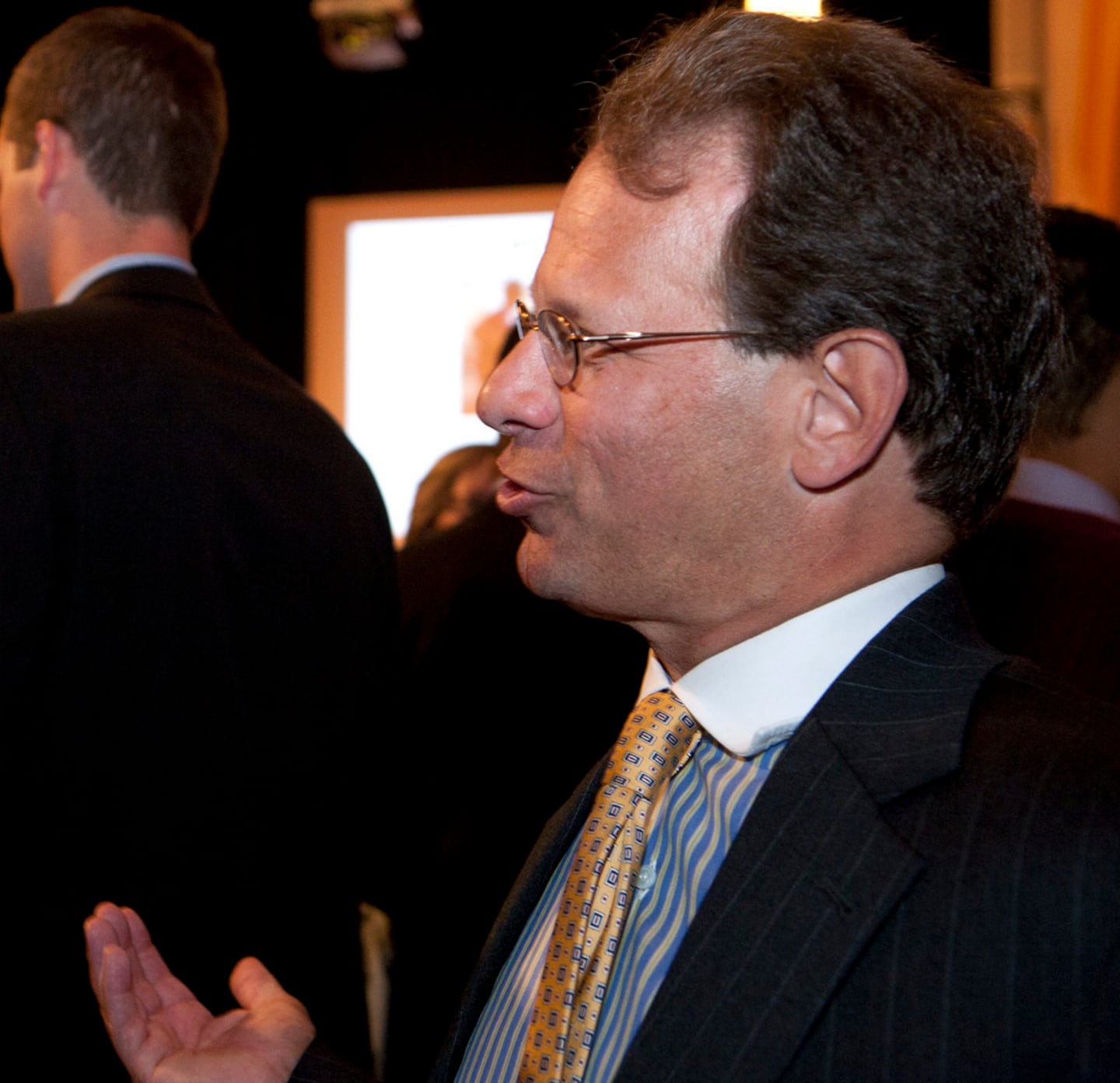 Robert Maginn speaking with people at an indoor political gathering