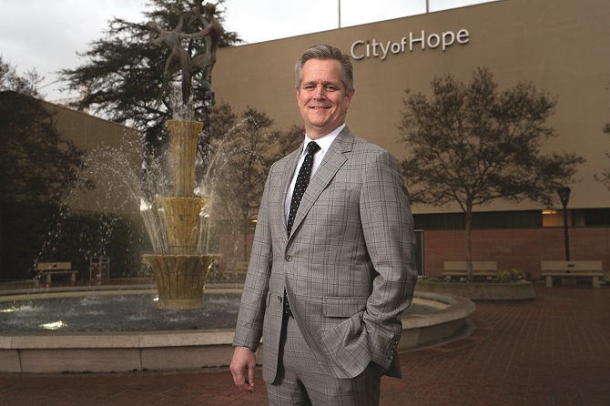 Robert Stone standing beside a fountain on the City of Hope campus